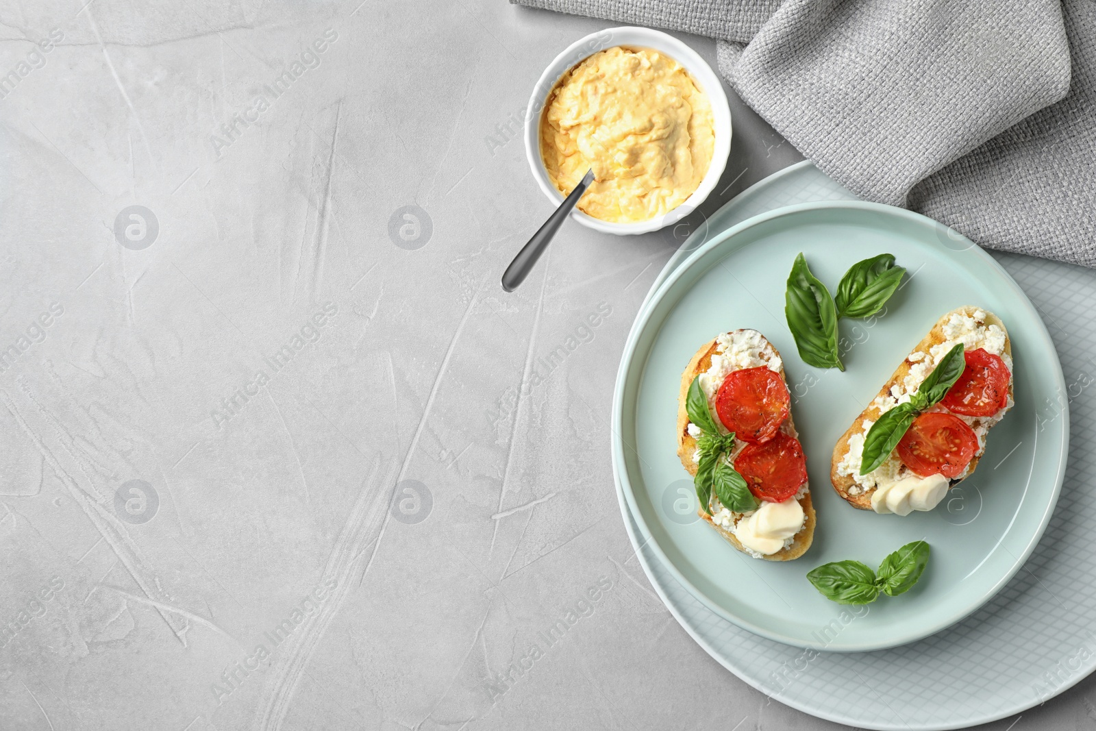 Photo of Tasty fresh tomato bruschettas on grey table, flat lay. Space for text