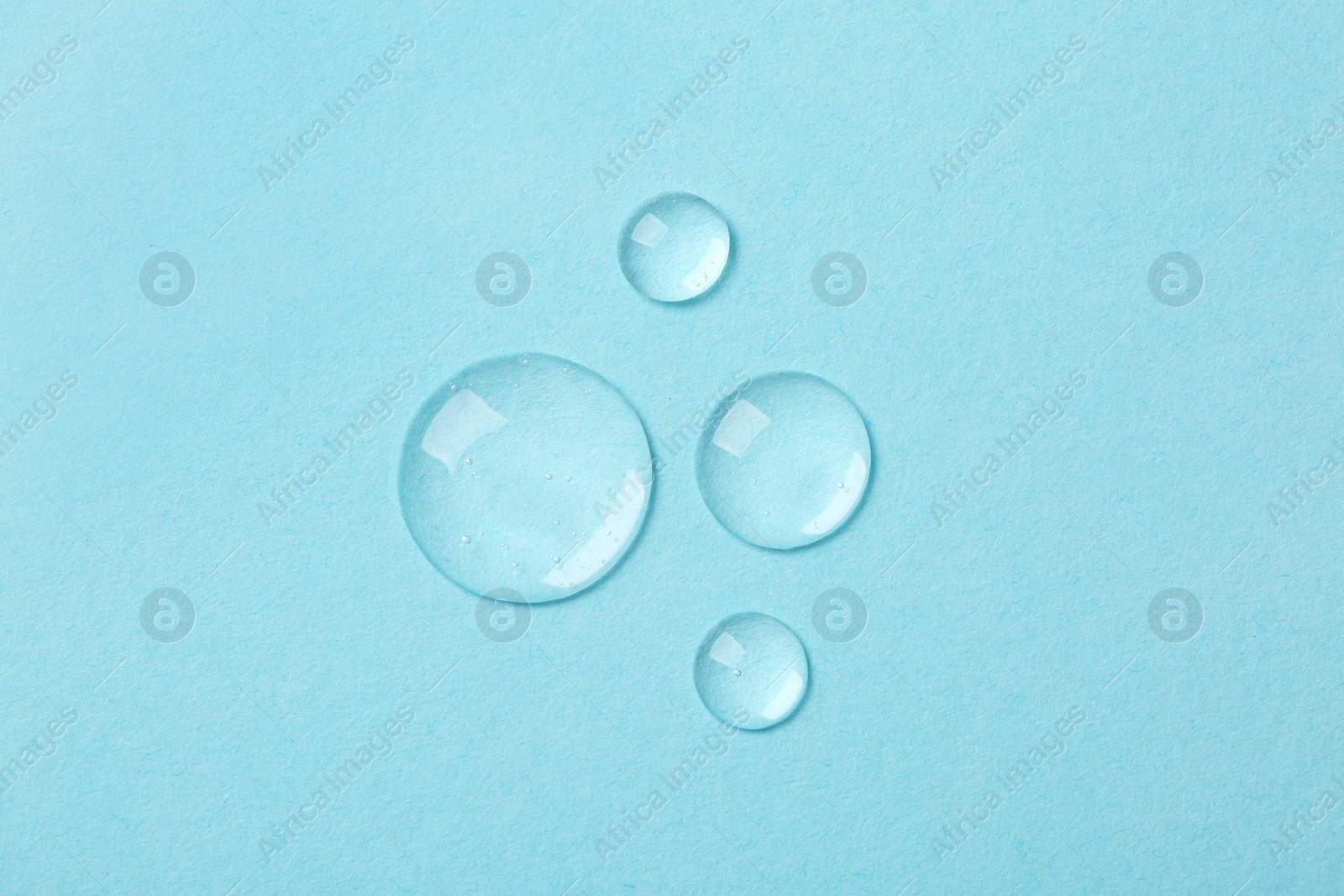Photo of Samples of cosmetic serum on light blue background, flat lay