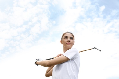 Photo of Woman playing golf against blue sky, low angle view
