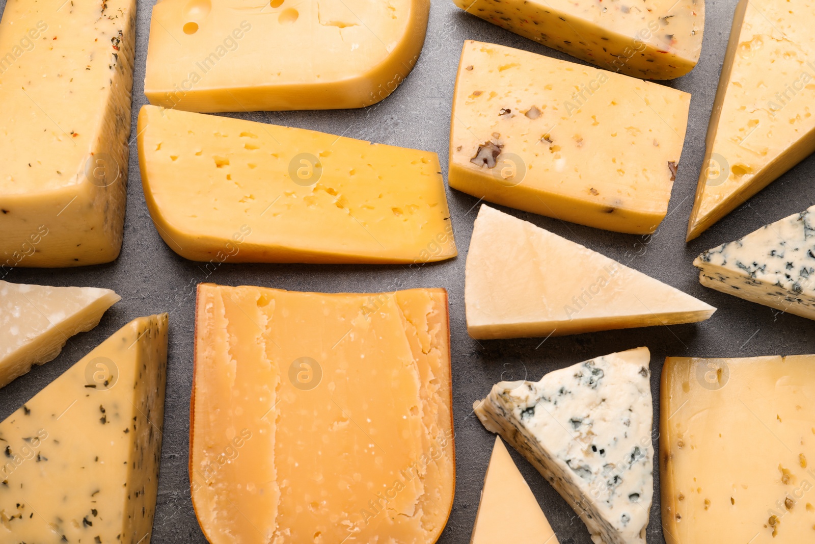 Photo of Different kinds of delicious cheese on stone background, top view