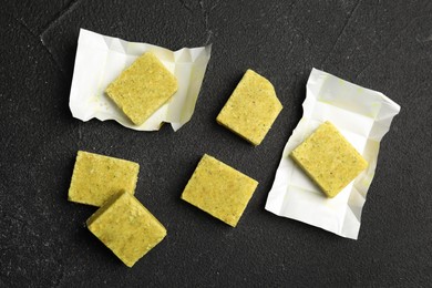 Aromatic natural bouillon cubes on black table, flat lay