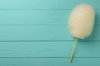 One sweet cotton candy on turquoise wooden table, top view. Space for text