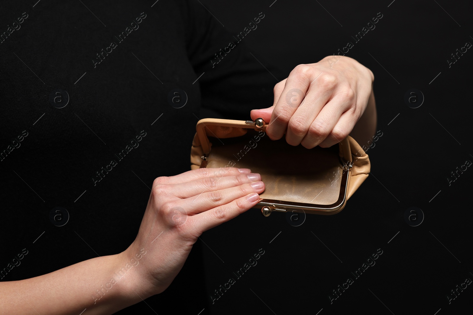 Photo of Woman with empty wallet on black background, closeup
