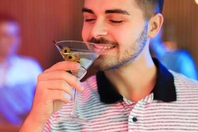 Photo of Young man with glass of martini cocktail at party