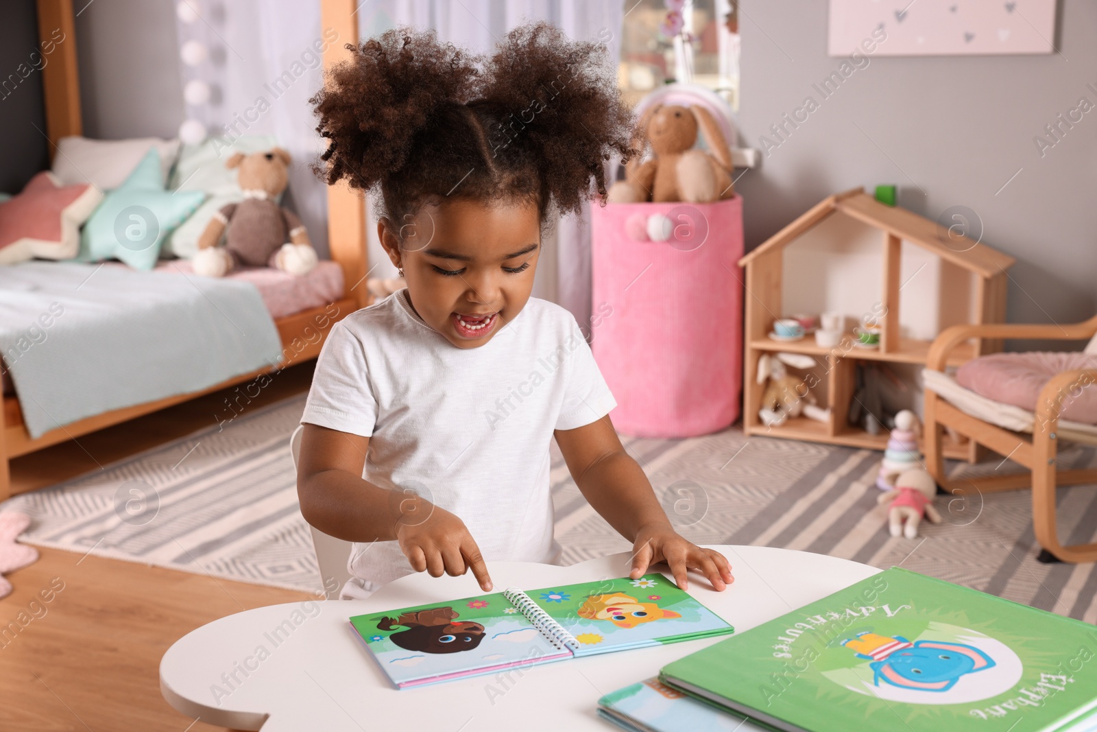 Photo of African American girl reading book at home