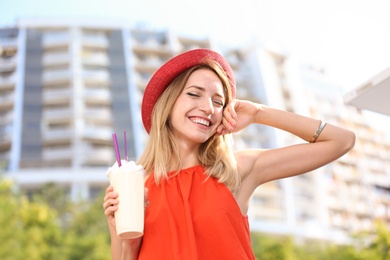 Beautiful woman with tasty drink on city street