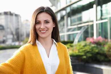 Young female journalist working on city street