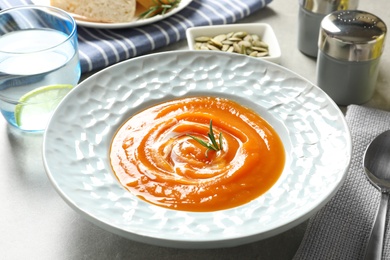 Plate of tasty sweet potato soup served on table