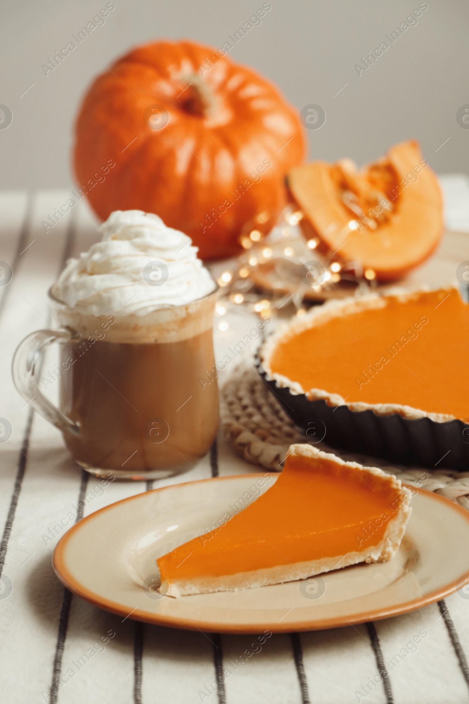 Photo of Fresh homemade pumpkin pie and cup of cocoa with whipped cream on table