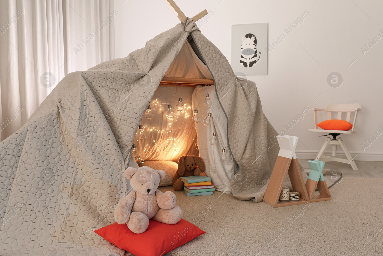 Photo of Play tent decorated with festive lights in modern child's room
