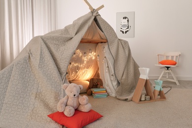 Play tent decorated with festive lights in modern child's room