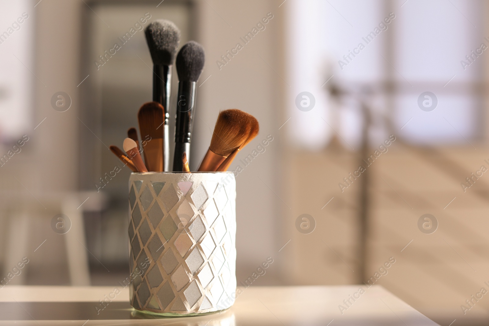 Photo of Holder with makeup brushes on table