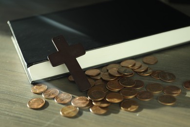 Photo of Donate and give concept. Coins, cross and Bible on wooden table