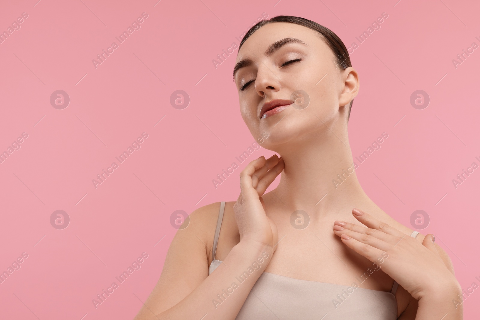 Photo of Beautiful woman touching her neck on pink background. Space for text