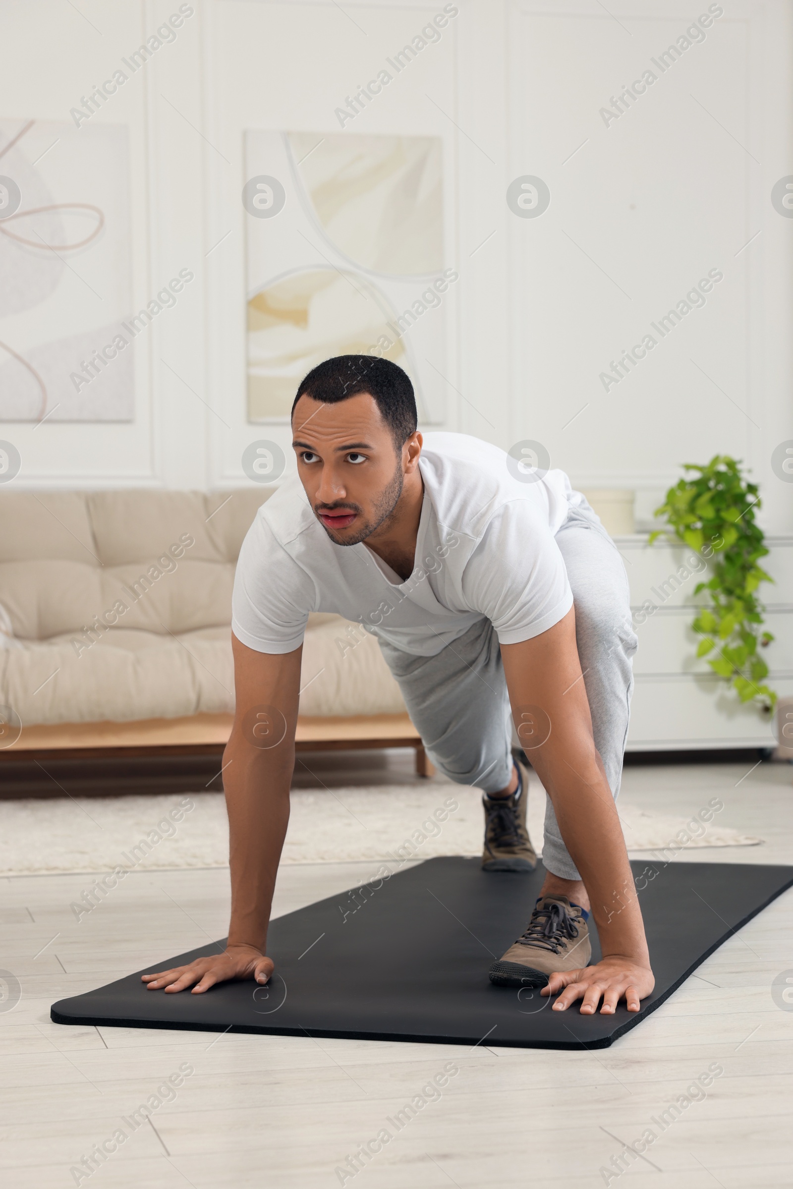 Photo of Man doing morning exercise on fitness mat at home