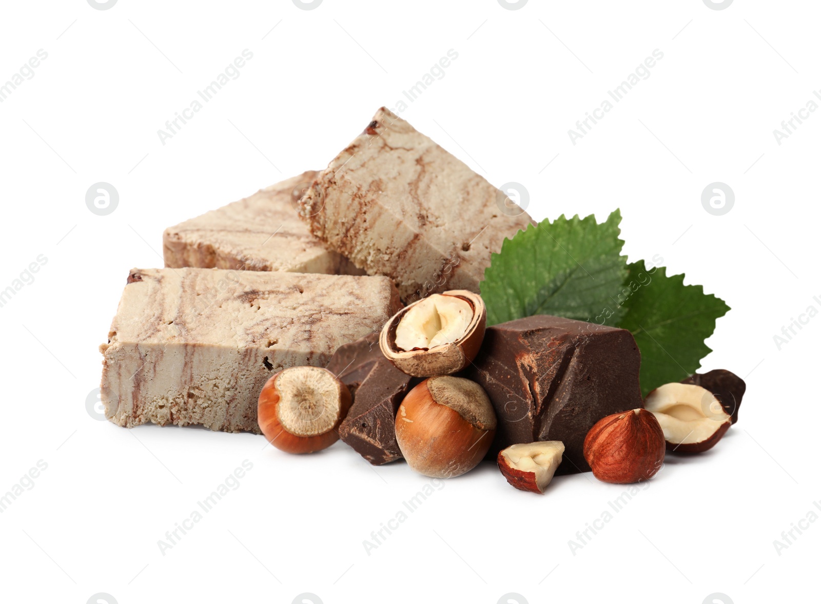 Image of Tasty halva, pieces of chocolate, hazelnuts and green leaves isolated on white