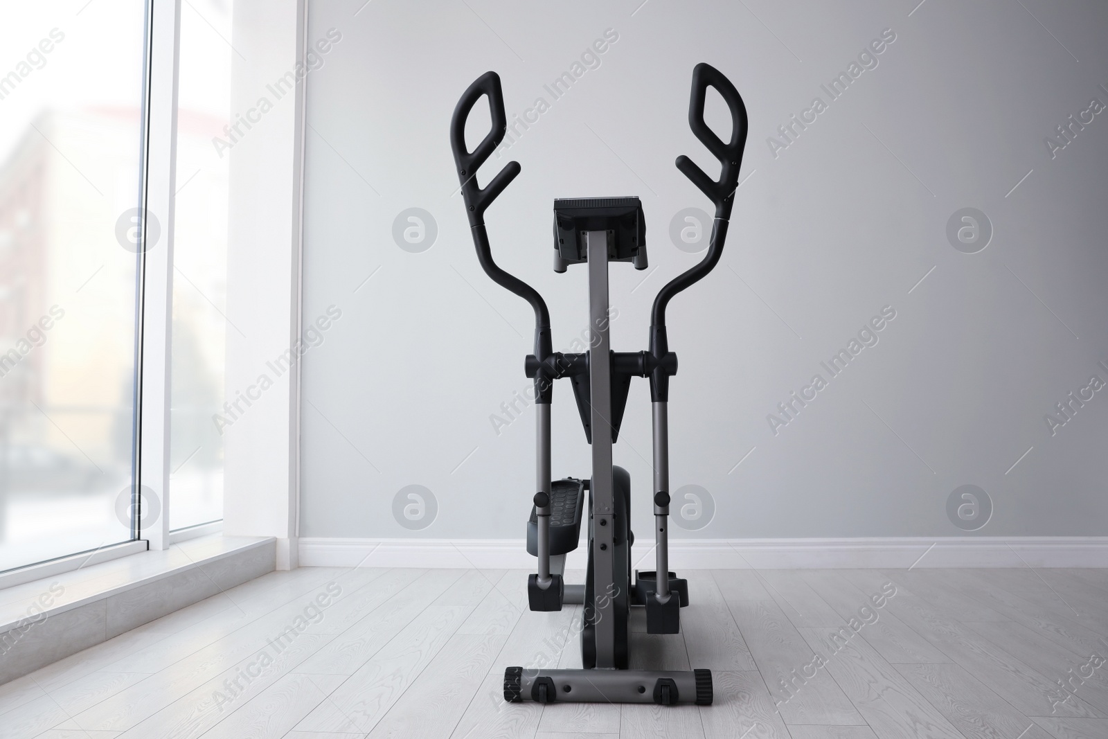 Photo of Elliptical machine cross trainer near window indoors