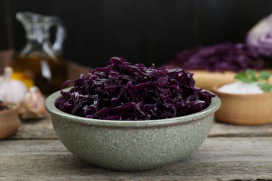 Photo of Tasty red cabbage sauerkraut with parsley on wooden table