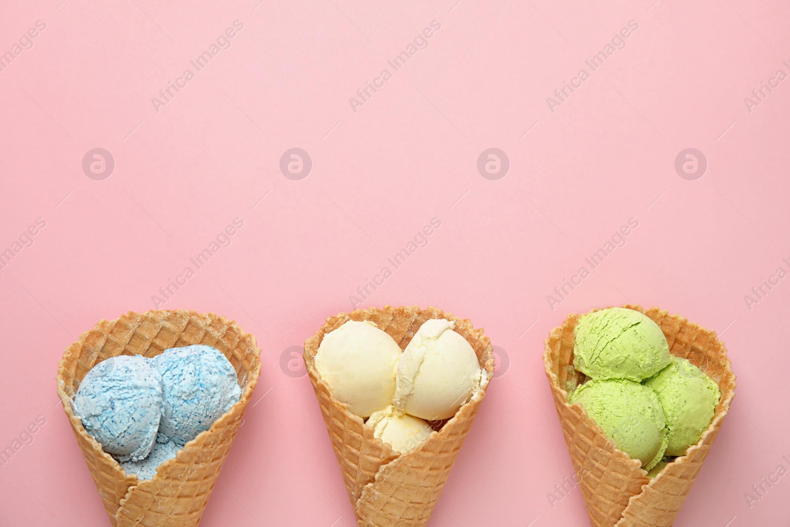 Photo of Flat lay composition with delicious ice creams in waffle cones on color background, space for text