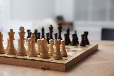 Photo of Chess board with pieces on wooden table