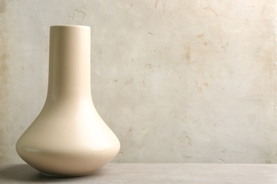 Stylish empty ceramic vase on grey table, space for text