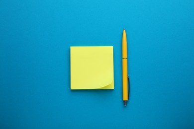 Photo of Paper note and pen on blue background, top view