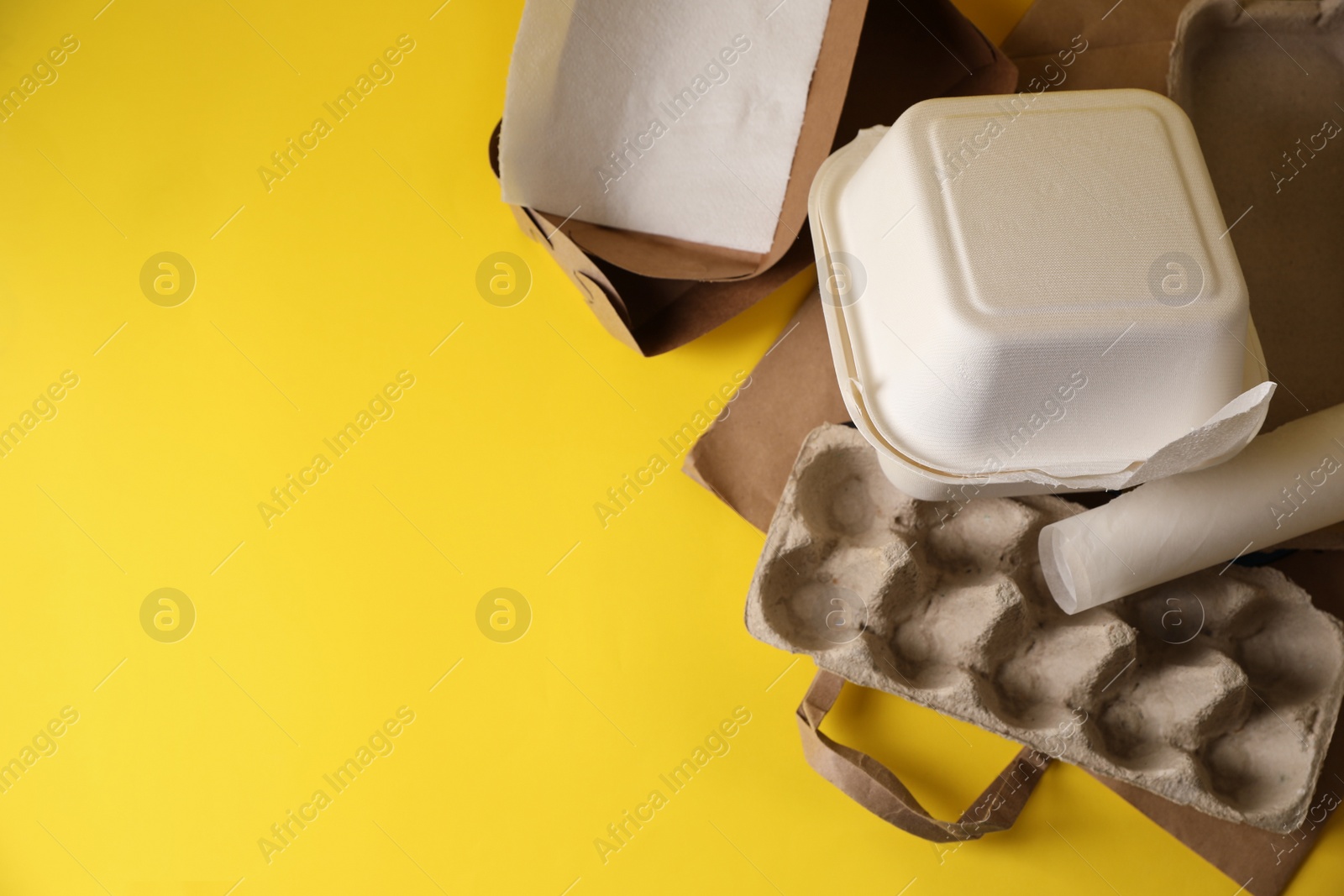 Photo of Heap of waste paper on yellow background, flat lay. Space for text