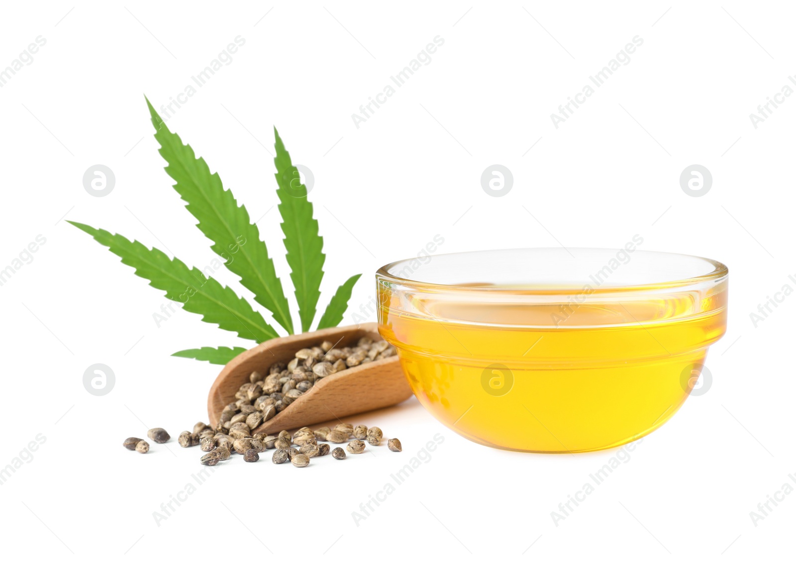 Photo of Bowl of hemp oil, fresh leaf and seeds on white background