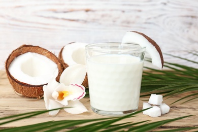 Glass of coconut milk on wooden background