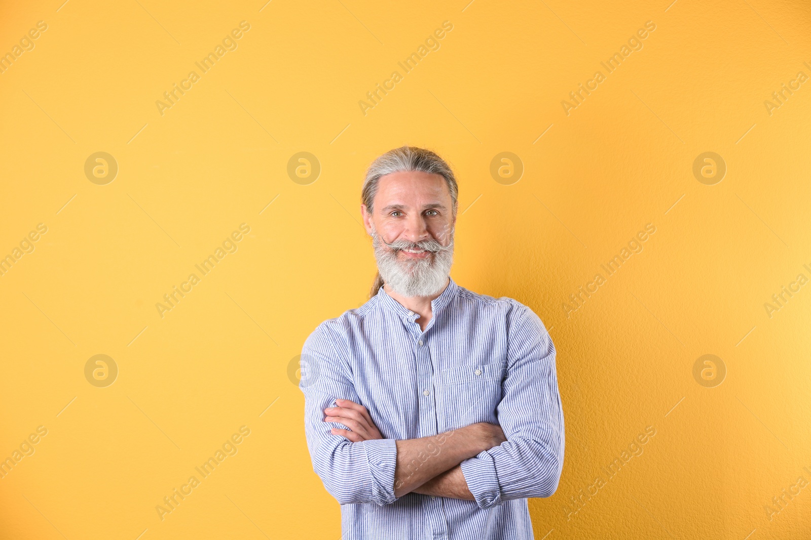 Photo of Portrait of handsome mature man on color background