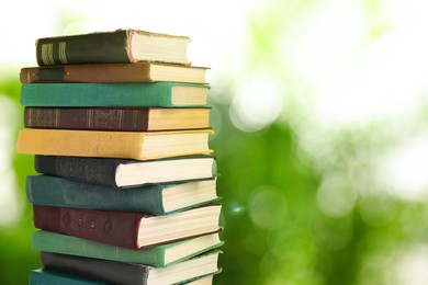 Image of Many stacked hardcover books against blurred background, space for text