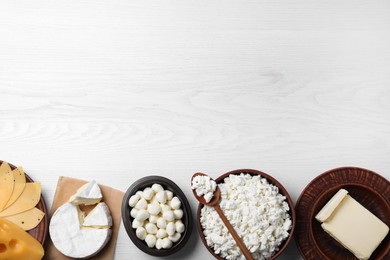 Photo of Clay dishware with fresh dairy products on white wooden table, flat lay. Space for text