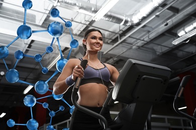 Image of Metabolism concept. Molecular chain illustration and young woman working out on elliptical trainer in modern gym
