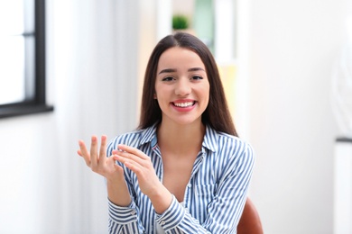 Beautiful woman using video chat for conversation indoors