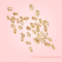 Image of Rolled oat flakes falling on pink background