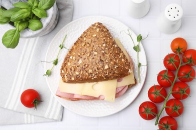 Delicious sandwich with ham, cheese and products on white table, flat lay