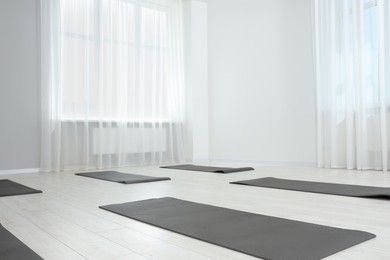 Photo of Spacious yoga studio with exercise mats. Space for text
