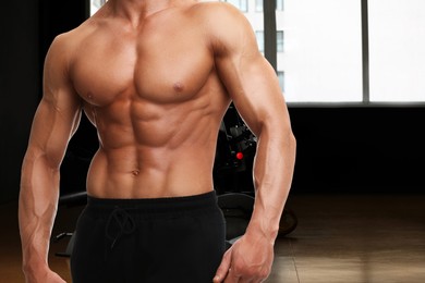 Bodybuilder with muscular body in gym, closeup. Space for text