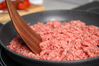 Photo of Frying pan with raw minced meat on induction stove, closeup