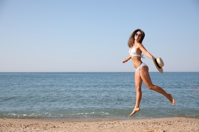 Photo of Young woman with beautiful body on beach. Space for text