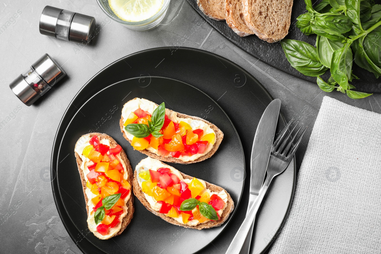 Photo of Tasty fresh tomato bruschettas on grey table, flat lay