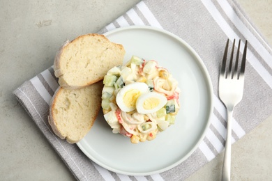 Photo of Delicious salad with crab sticks and eggs served on grey table, flat lay