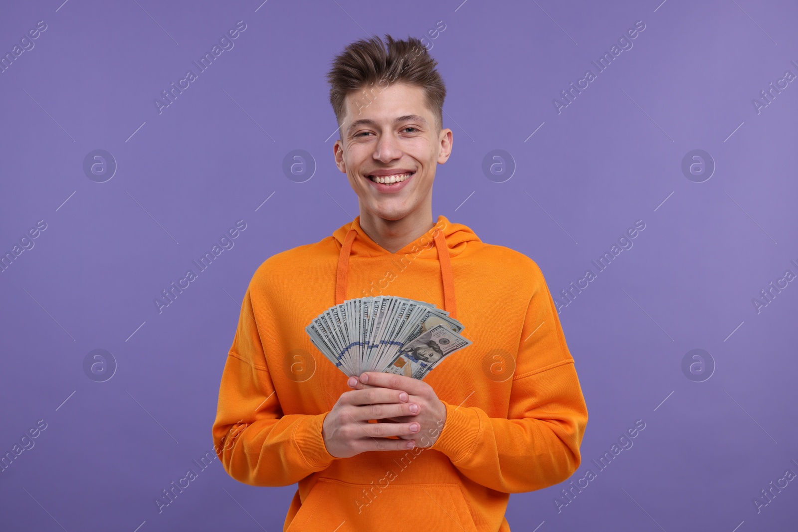 Photo of Happy man with money on purple background