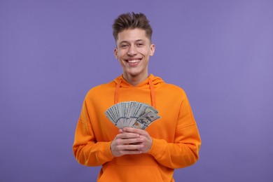 Photo of Happy man with money on purple background