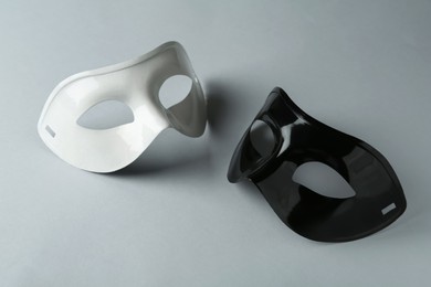 Photo of White and black theatre masks on grey background