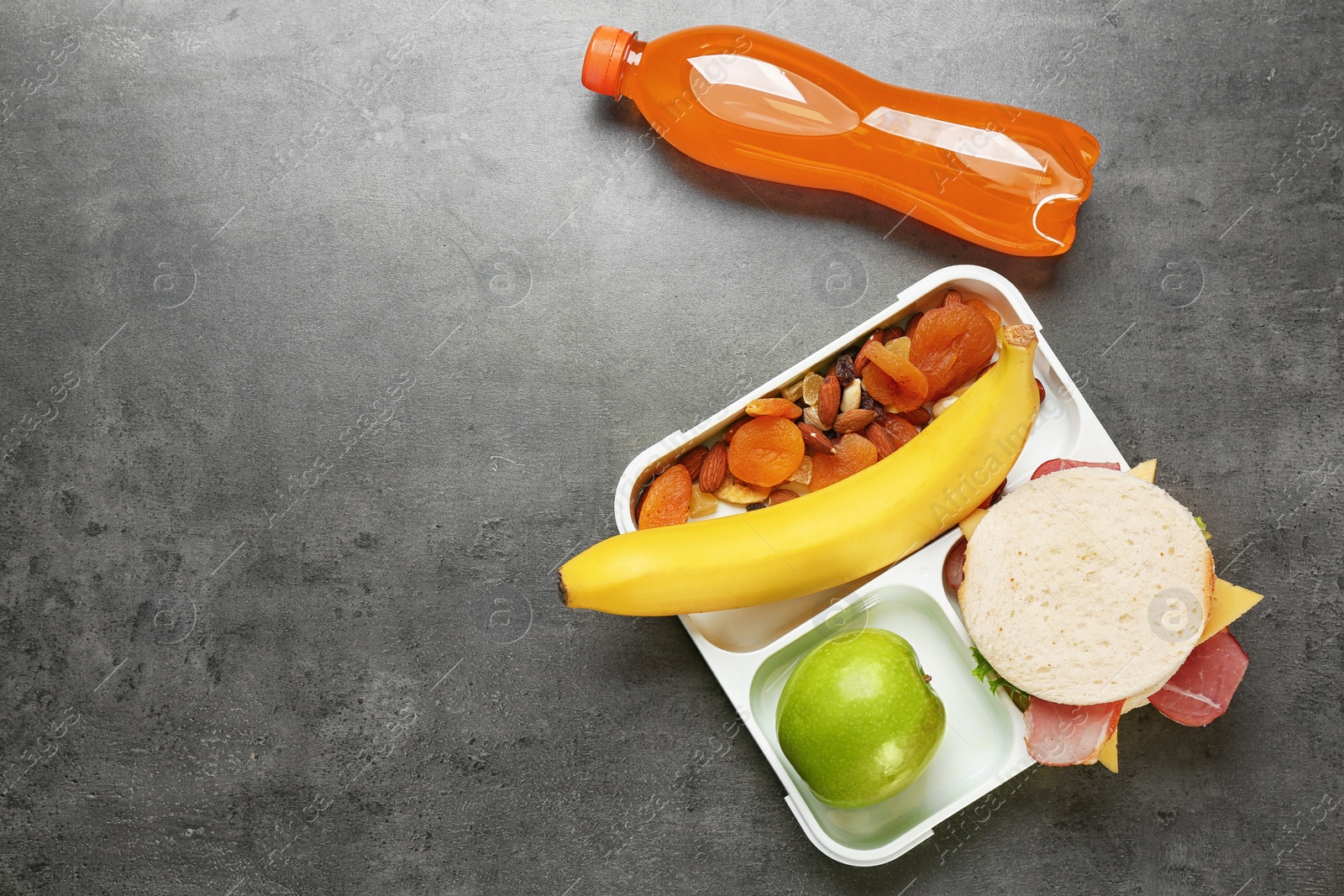 Photo of Lunch box with appetizing food bottle of juice on grey background, top view