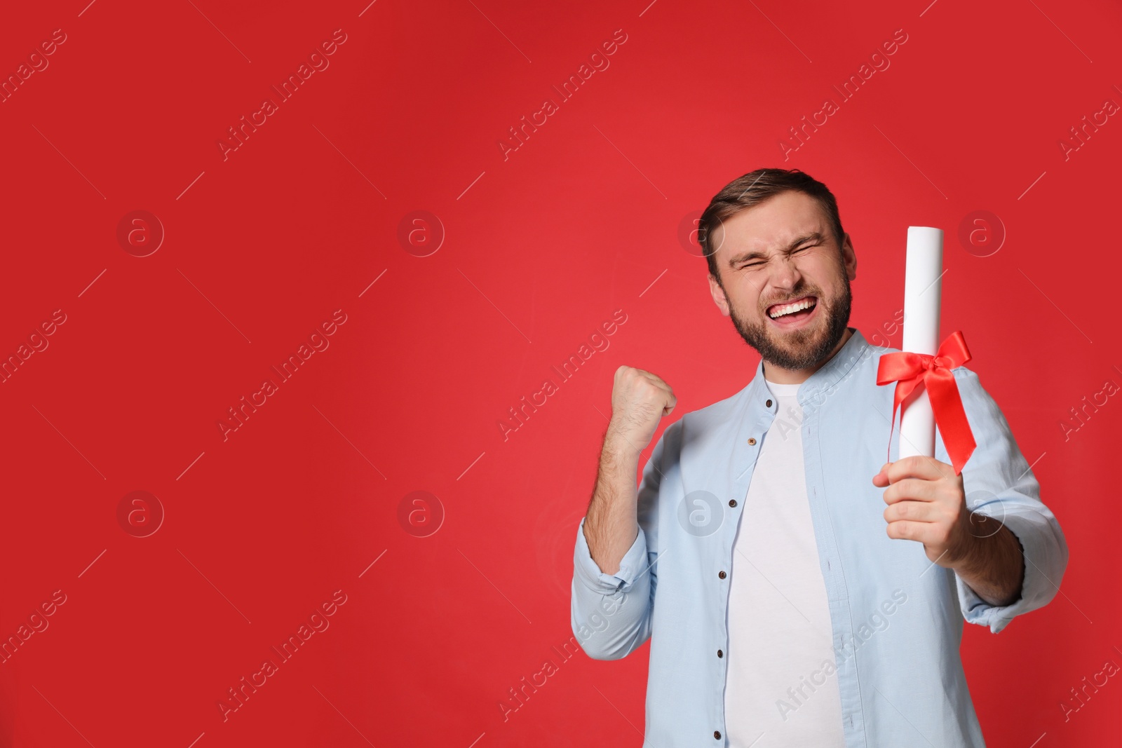Photo of Emotional student with diploma on red background. Space for text