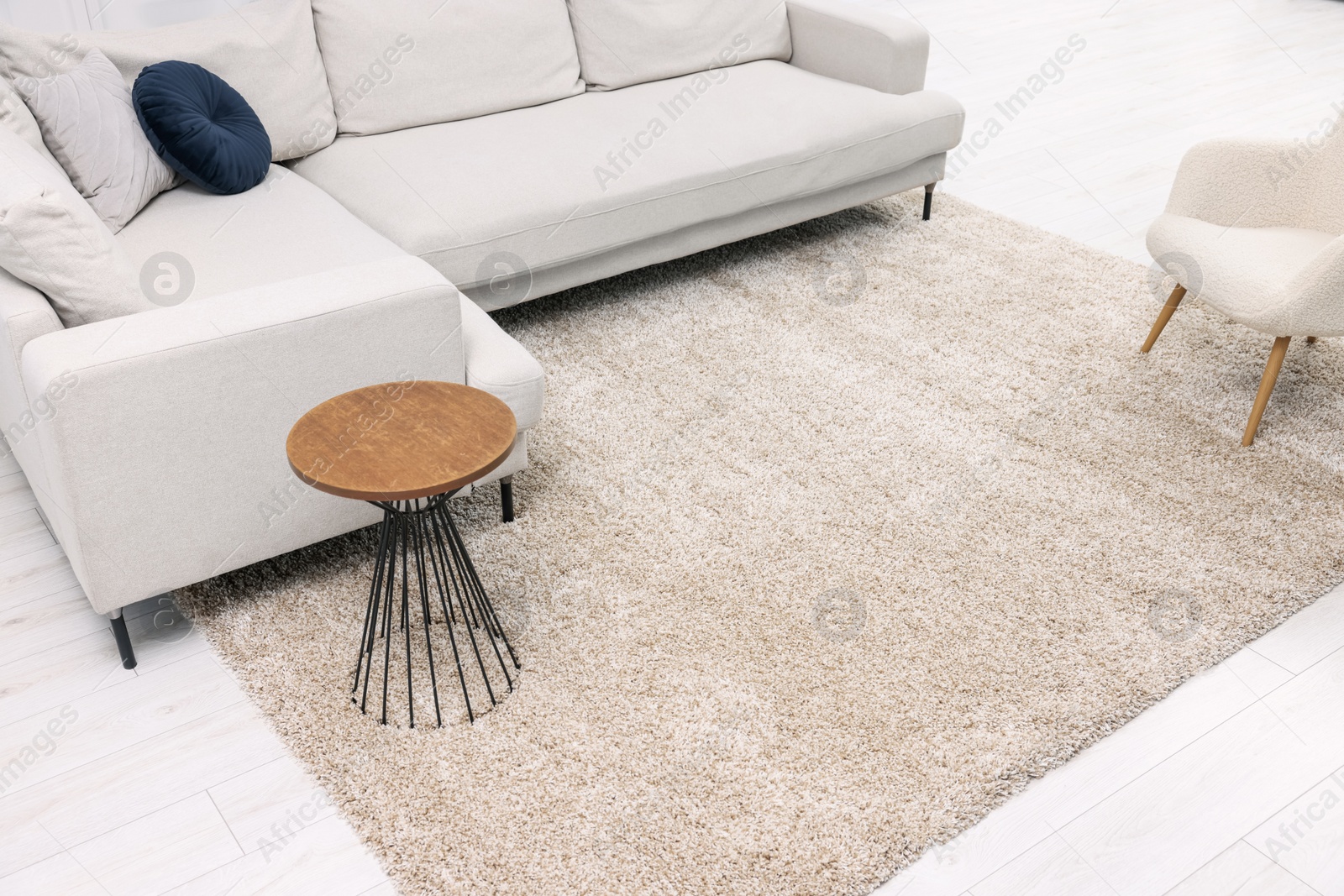 Photo of Fluffy carpet and stylish furniture on floor indoors
