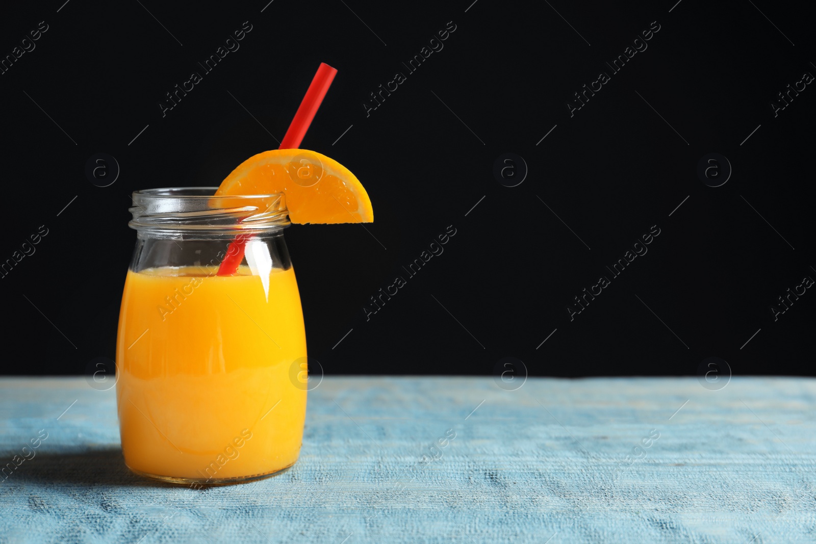 Photo of Jar of orange juice on wooden table