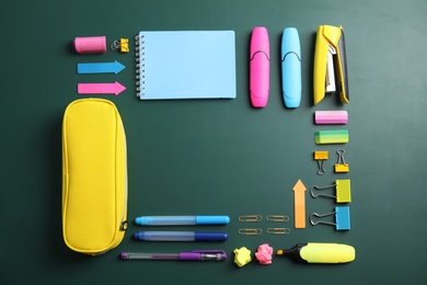 Photo of Flat lay composition with different school stationery on chalkboard surface